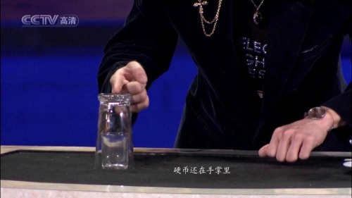 引用 如何成為一個(gè)魔術(shù)高手——?jiǎng)⒅t魔術(shù)全解密 - zhuhuasohu - 汩汩的博客 看似很嫻熟地把小玻璃杯放到桌面上,其實(shí)是非常仔細(xì)地放到出口的旁邊,這個(gè)位置要使硬幣出口處于小玻璃杯底座和大玻璃杯口之間.劉謙可以用右手或者腳啟動(dòng)一個(gè)隱蔽的開關(guān),使彈簧機(jī)構(gòu)動(dòng)作將硬幣彈射上去,這個(gè)機(jī)關(guān)我們不去思考了,因?yàn)楦静挥觅M(fèi)腦筋,這不是魔術(shù)的關(guān)鍵.硬幣彈射上去后,經(jīng)過小玻璃杯的杯口和大玻璃杯的內(nèi)杯壁之間的縫隙,上升到大玻璃杯的底座后,被反射回來,掉到小玻璃杯里.由于彈簧的發(fā)射速度快,硬幣上升過程用肉眼根本看不出來,人們只是看到硬幣瞬間在小玻璃杯里面,感到很驚奇.